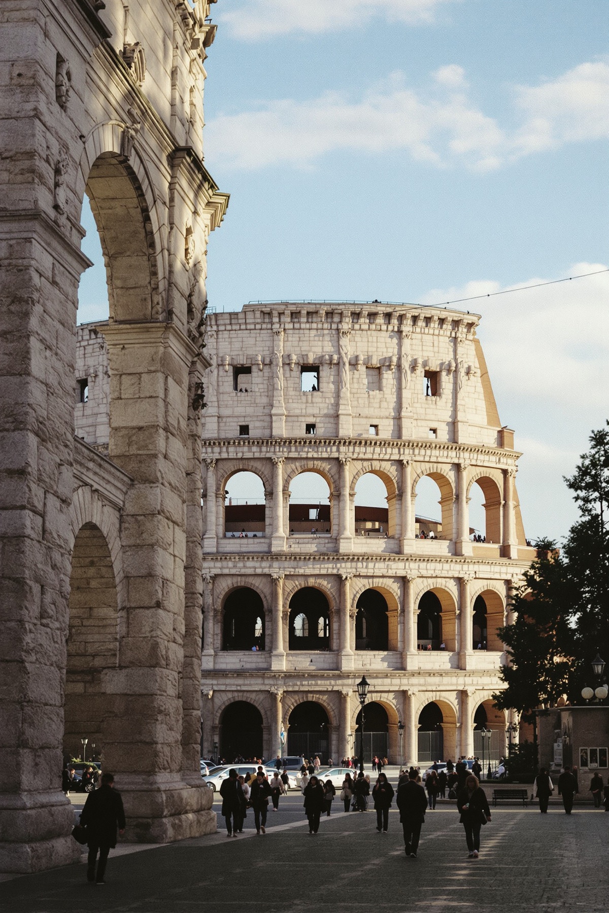 The Colosseum in Rome in morning light, seen through an ancient arch